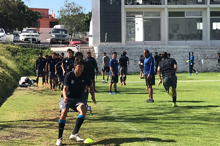フィジカルコーチの指導のもと、アップを行うケレタロの下部組織の選手たち【写真：福岡吉央】