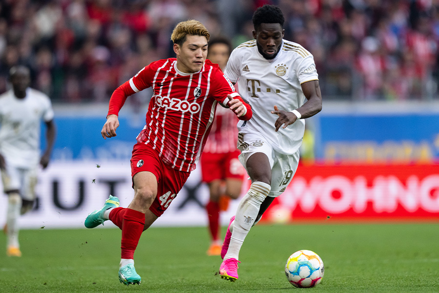 アルフォンソ・デイビスとマッチアップする堂安律【写真：Getty Images】