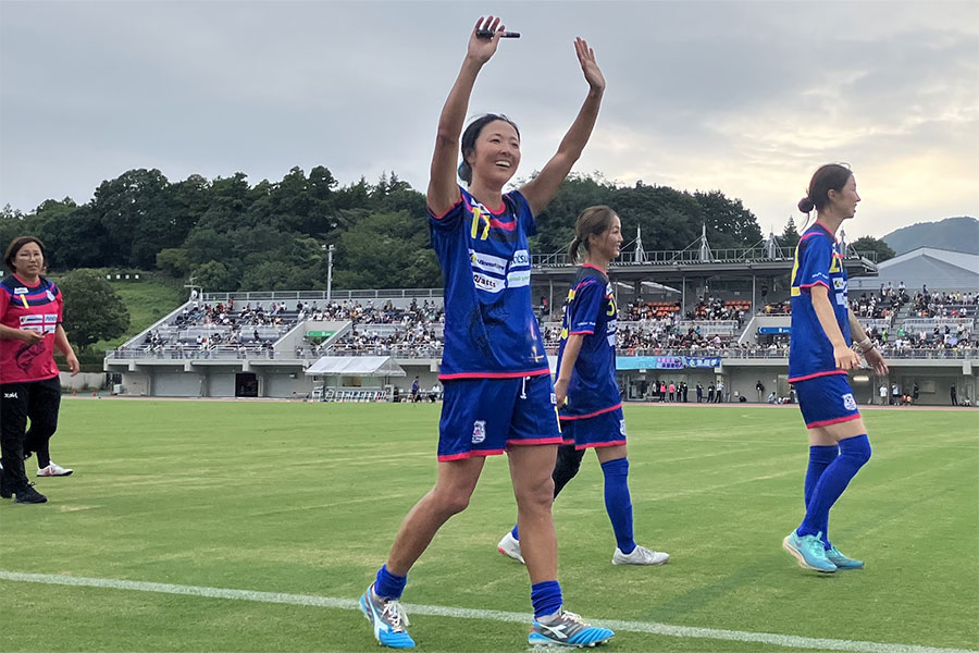 競技場を一周してサインを書きながら、スタンドに笑顔で手を振る永里さん【写真：砂坂美紀】