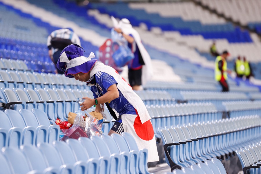 日本代表ファンがゴミを拾う様子(写真はW杯2022年大会)【写真:USA TODAY Sports/ロイター/アフロ】